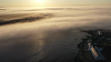 Kilkee, Co. Clare 'in kayalık sahillerinde puslu bir gün doğumu. İrlanda