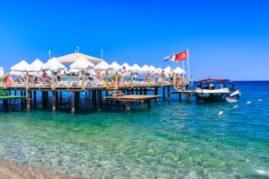 Tekirova, Türkiye - 6 Temmuz 2024: Tekirova 'da Türk Riviera plajındaki insanlar. Tekirova, Türkiye 'nin Akdeniz kıyısında Antalya iline bağlı bir beldedir.