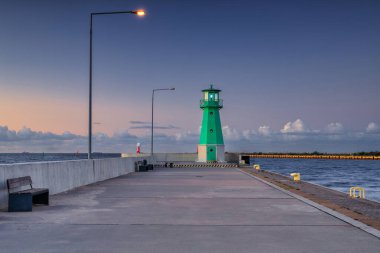 Günbatımında Nowy Limanı 'nın batı dalgakıranında yeşil deniz feneri, Gdansk.