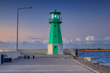 Günbatımında Nowy Limanı 'nın batı dalgakıranında yeşil deniz feneri, Gdansk.