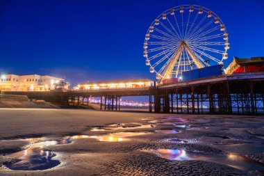 Beautiful landscape of Blackpool beach with illuminated pier and ferris wheel at dusk. United Kingdom clipart