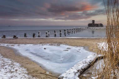 Gün batımında Babie Doly 'de donmuş Baltık Denizi plajı, Gdynia. Polonya