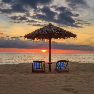 Gün batımında Tayland 'da bir plajda güneşlik.