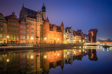 Gdansk 'taki Motlawa nehrinin kıyısındaki eski şehrin güzel mimarisi. Kış gecesinde tarihi bir iskele vinci var. Polonya