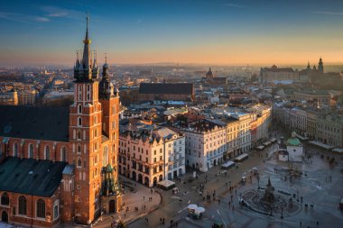 Krakow, Polonya - 17 Ocak 2025: Krakow 'daki Ana Pazar Meydanı batan güneşin ışığında. Polonya