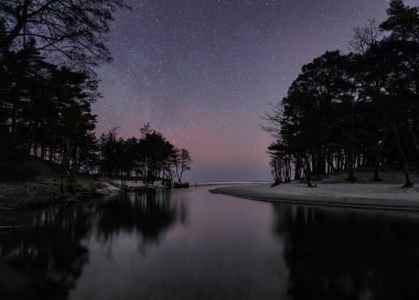 Polonya 'nın Debki kentindeki Piasnica Nehri üzerinde yıldızlı gökyüzü