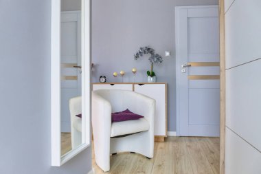 Soyunma odasındaki aynanın yanındaki koltuk.