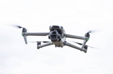 Rotmanka, Polonya - 24 Nisan 2025: DJI Air 3S beyaz zemin üzerinde uçan iki lens titreşimli İHA.
