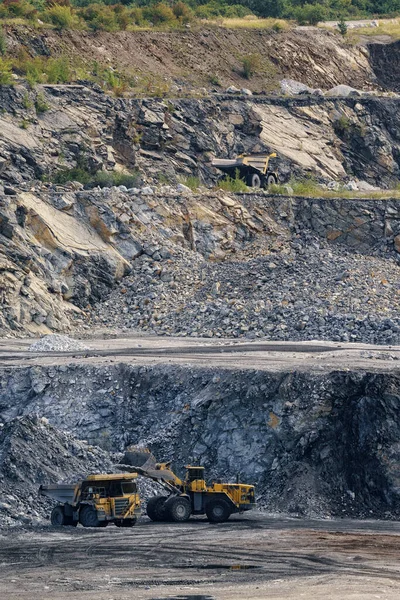ダンプトラックにホイールローダーで石をロードします 採石場の石の採掘 — ストック写真