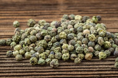 Kurutulmuş yeşil biber. Tahtadaki karabiber..