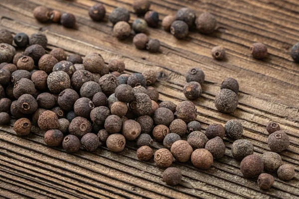 stock image Allspice spice on dark rustic wooden background.