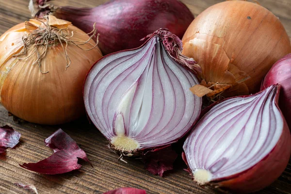 stock image Yellow and red onions on a wooden board