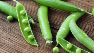 Ahşap arka planda taze bezelye kabukları