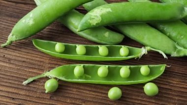 Ahşap arka planda taze bezelye kabukları