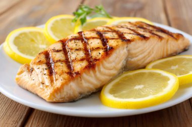 Lezzetli ızgara somon filetosu baharatlı ve beyaz tabakta taze limon dilimleriyle servis ediliyor. Yapay zeka üretken
