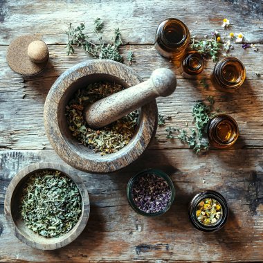 Tahta havan ve tokmak öğütücü kurutulmuş otlar küçük eczacı şişeleri ile kırsal ahşap masa üzerinde doğal bir ilaç konsepti yaratıyor. Yapay zeka üretken