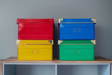 Canlı bir oyun odasında oyuncaklar ve oyunlar düzenlemek için dört renkli metal kutu bir rafta güzelce düzenlenir. Yapay zeka üretken