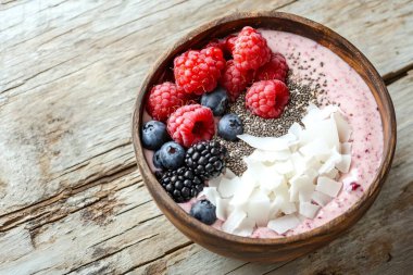 Ahududu, böğürtlen, böğürtlen, chia tohumu ve hindistan cevizi gevreğiyle ahşap kasede servis edilen lezzetli smoothie kasesi. Yapay zeka üretken