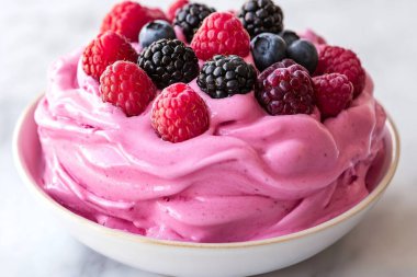 Taze ahududu, yaban mersini ve böğürtlenli bir kase dondurma, canlı ve ferahlatıcı bir tatlı yaratır. Yapay zeka üretken