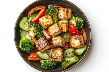 Susam aromalı tofu ve sebze tabağı koyu bir kasede servis edilir, sağlıklı ve lezzetli bir yemek sunulur. Yapay zeka üretken