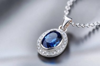 Büyük, oval şekilli, daha küçük, parlak taşlarla çevrili mavi bir mücevher içeren zarif gümüş kolye lüks ve sofistike bir görünüm yaratıyor. Yapay zeka üretken