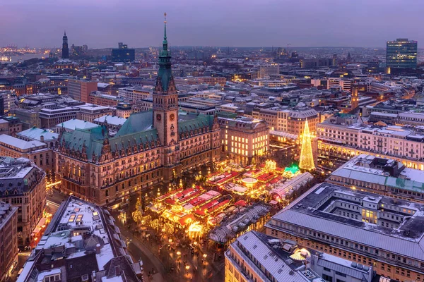Almanya 'nın Hamburg kentinde, Rathausmarkt' ta akşam saatlerinde aydınlatılmış tarihi Noel pazarının havadan görünüşü.