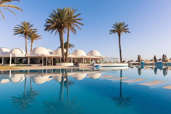 突尼斯 带有穹顶的传统建筑的游泳池和棕榈树 图库照片