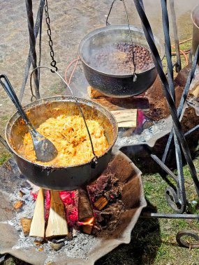 Kamp ateşinde bir kazanda yemek pişirmek.