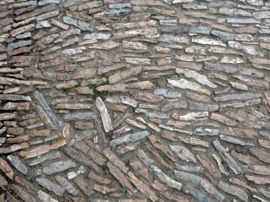 Antique pavement made of natural uneven narrow stones