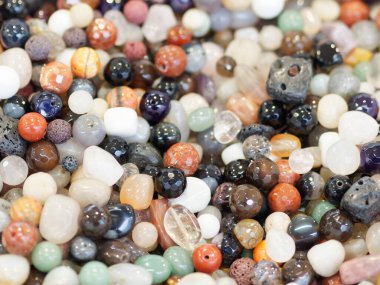 Mücevher, yarı değerli taş boncuklar ve aletlerle düzlük yapıyor. El yapımı mücevherler, küçük işletmeler, hobi konsepti.