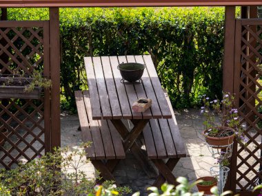 Bahçedeki bir taraçanın altındaki tahta masa.