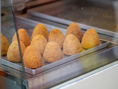 Arancini (deep fried rice balls with meat) Typical Sicilian street food at market in Italy clipart