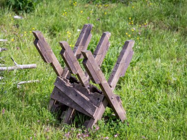 Odunları odun ocağına dönüştürmek için kullanılan tahta bir at çimenli bir çayırda oturur..