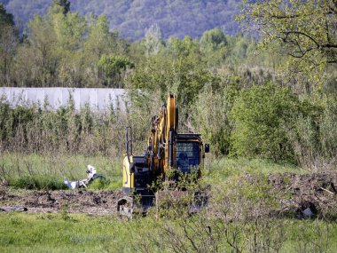 Gün batımında inşaat alanında kazıcı