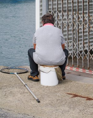 Günbatımında La Spezia körfezinde balık tutan bir adam.