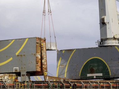 Package unit of the heavy life cargo being discharging or loading by the ship crane under supervisor by professional handling in the port terminal clipart