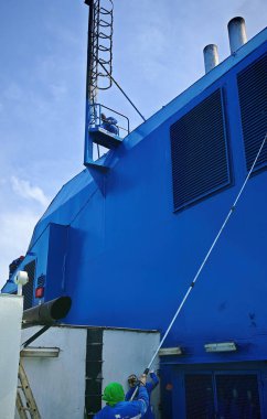  Bir gemi mürettebatı, savaş gemisine huni boyuyor.