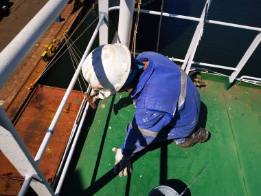 Bir gemi mürettebatı kargo gemisinde bakım sırasında çalışır ya da çip takar.