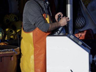 Bağlanma sırasında bir balıkçı teknesinde çalışıyor.