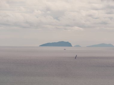 Tuscan archipelago Capraia ve Gorgona Adaları. İtalyan sahil sahil ve yelken tekne panoramik manzara. Corse veya arka plan Korsika'da. İtalya, Europe.