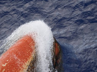 Büyük bir kargo gemisinin soğanlı yayı denizde suda hareket ediyor. Kapat..