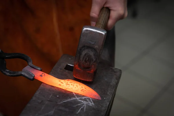 man hands are manufacturing a steel knife