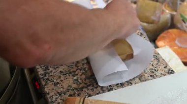 Adamın biri The Vacherin Fribourgeois 'in bir kısmını tel ile kesiyor. Ünlü bir İsviçre peyniri. 