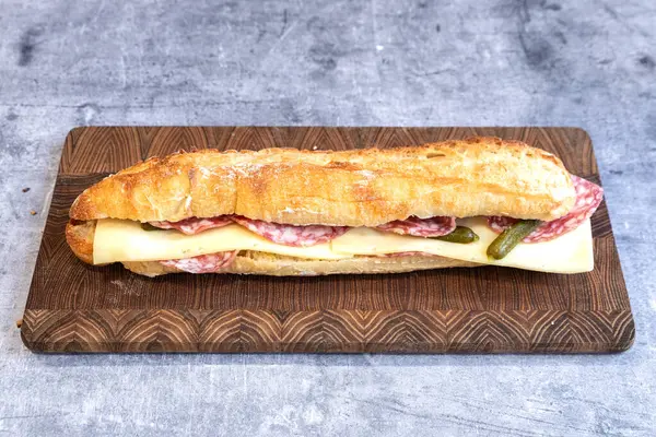 Tasty french sandwich with salami, cheese and baguette bread