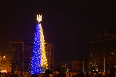KYIV, UKRAINE - 24 Aralık 2022: Kyiv 'deki Sofiyivska Meydanı' ndaki Noel ağacı beyaz güvercinler ve Kyiv 'in savaşla ilgili zorluklarla ve sonuçlarla başa çıkmasına yardım eden ülkelerin bayraklarıyla süslendi