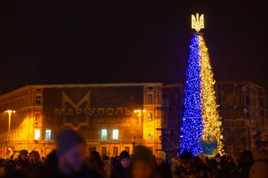 KYIV, UKRAINE - 24 Aralık 2022: Kyiv 'deki Sofiyivska Meydanı' ndaki Noel ağacı beyaz güvercinler ve Kyiv 'in savaşla ilgili zorluklarla ve sonuçlarla başa çıkmasına yardım eden ülkelerin bayraklarıyla süslendi