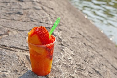 Sweet ice sorbet with mango taste with pepper chili powder and spices - Mexican traditional stret food