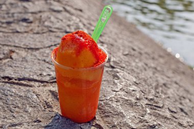 Sweet ice sorbet with mango taste with pepper chili powder and spices - Mexican traditional stret food