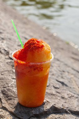 Sweet ice sorbet with mango taste with pepper chili powder and spices - Mexican traditional stret food