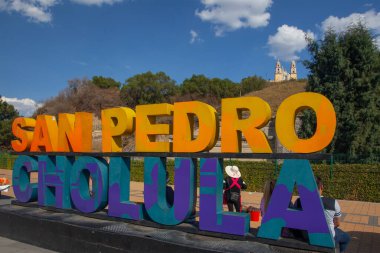 CHOLULA, PUEBLA, MEXICO - MARCH 18, 2022: Colorful Sign for San Andres de Cholula in front of the Giant Pyramid of Cholula and Santuario de la Virgen de los Remedios in Cholula, Mexico